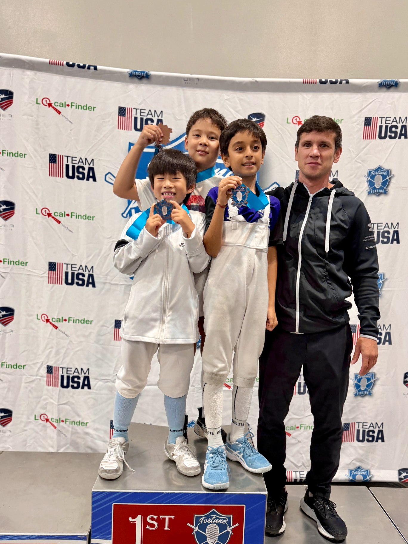 Medalists Ian, Euan, Neev with Coach Vakhob on the podium in Ontario