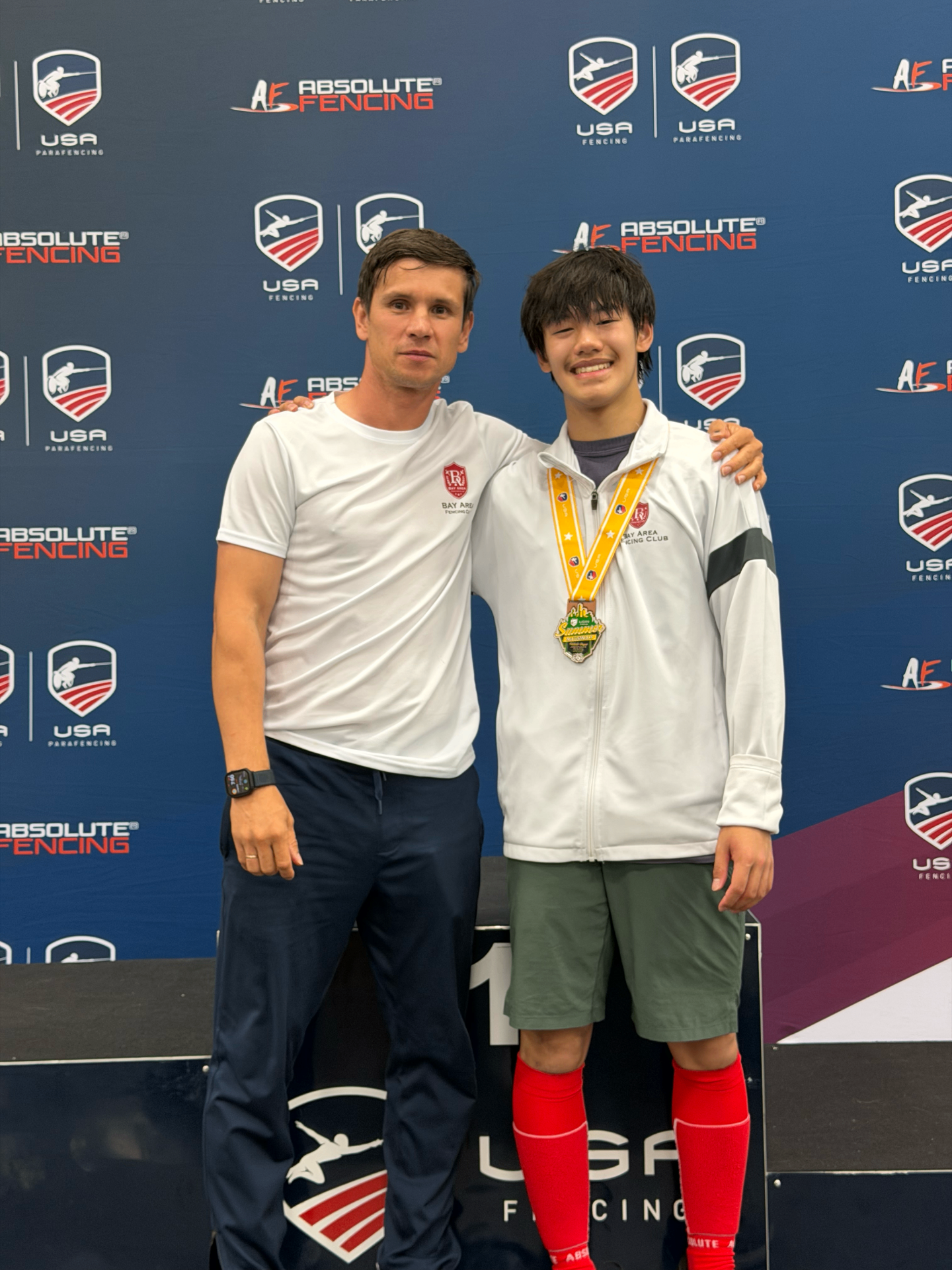 Coach Vakhob with BAFC medalist on the podium