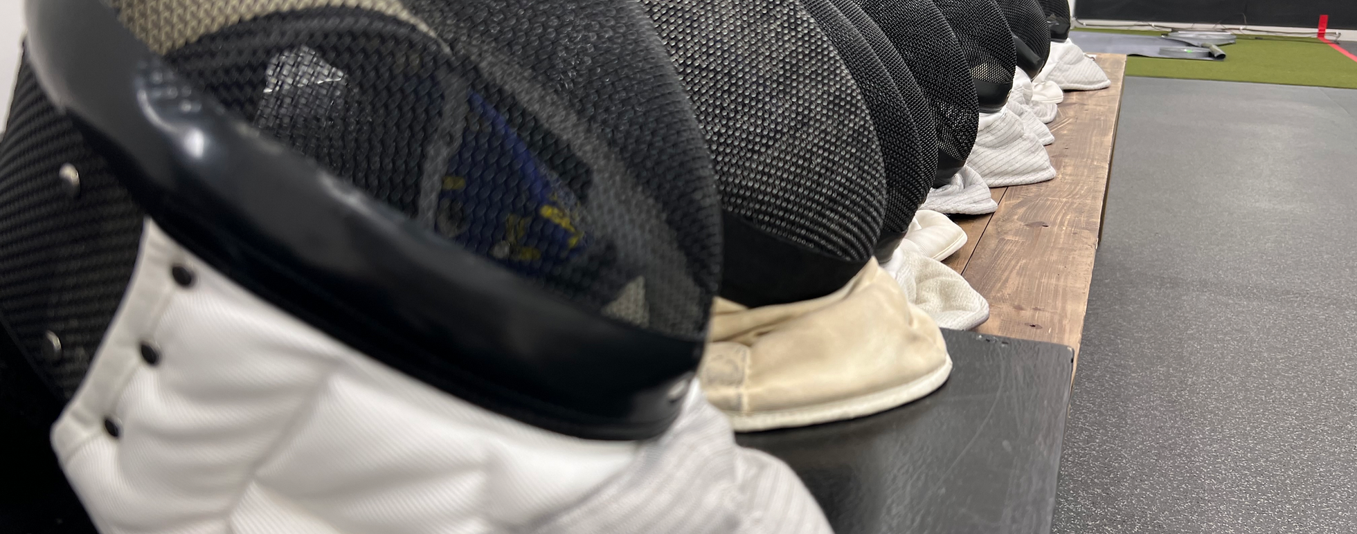 Row of fencing masks and gloves